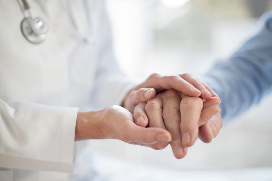 Female doctor holding patient's hand.